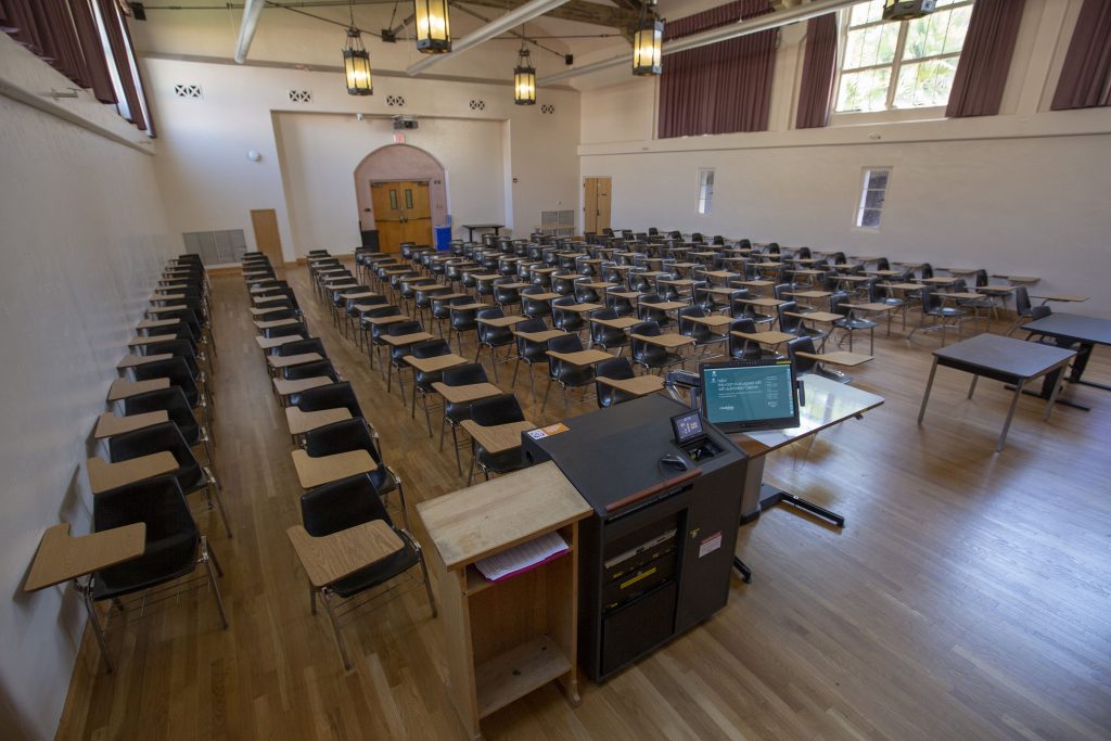 A large classroom with desks and an instructor podium